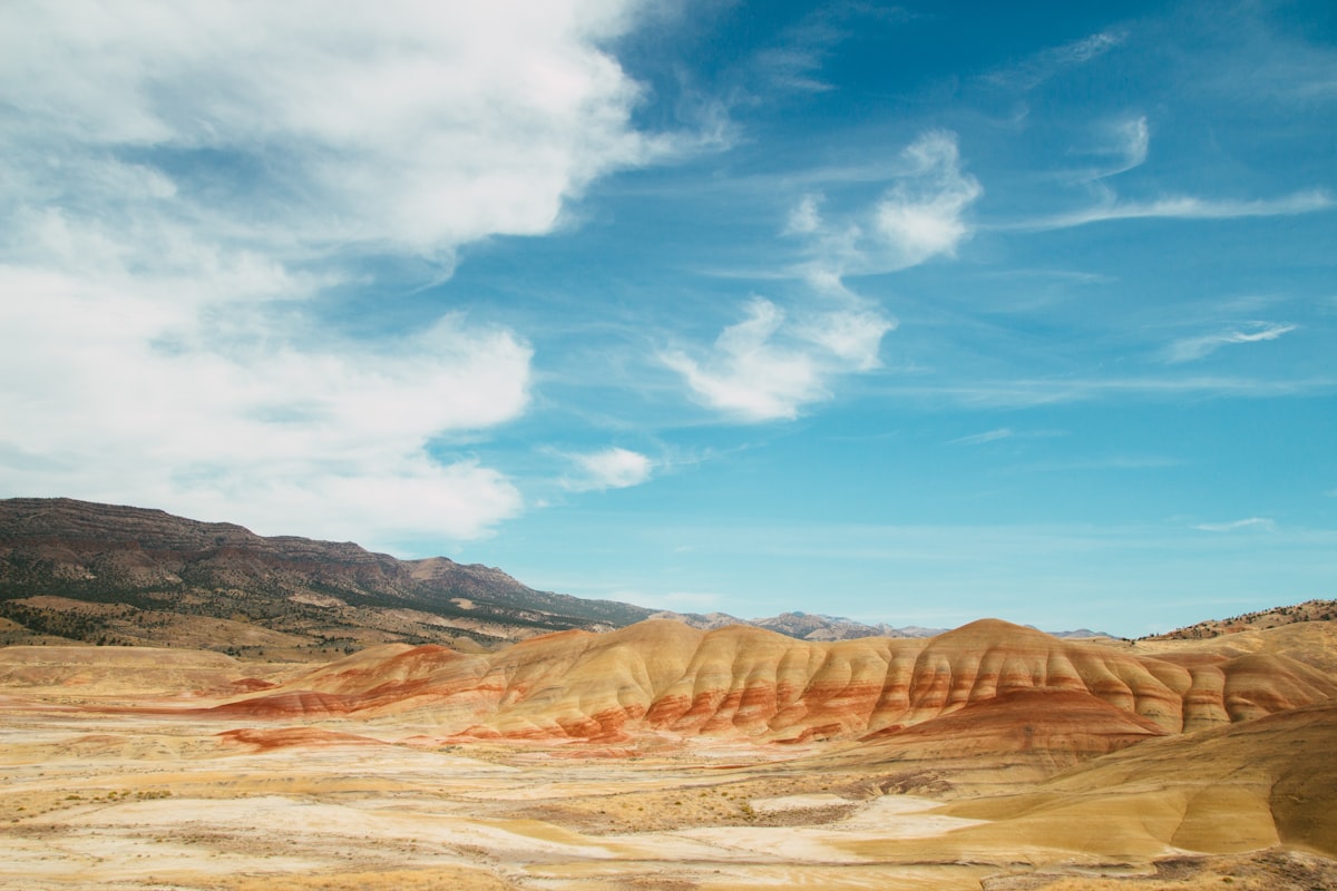 brown mountain under blue sky during daytime related to Deep Roots of the Past: Exploring John Day Fossil Beds