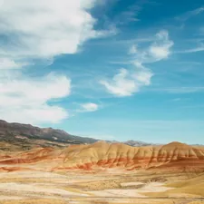 brown mountain under blue sky during daytime related to Deep Roots of the Past: Exploring John Day Fossil Beds