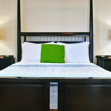brown wooden bed frame with white and pink floral bed linen related to Elevate Your Sleep Experience with a King Size Canopy Bed