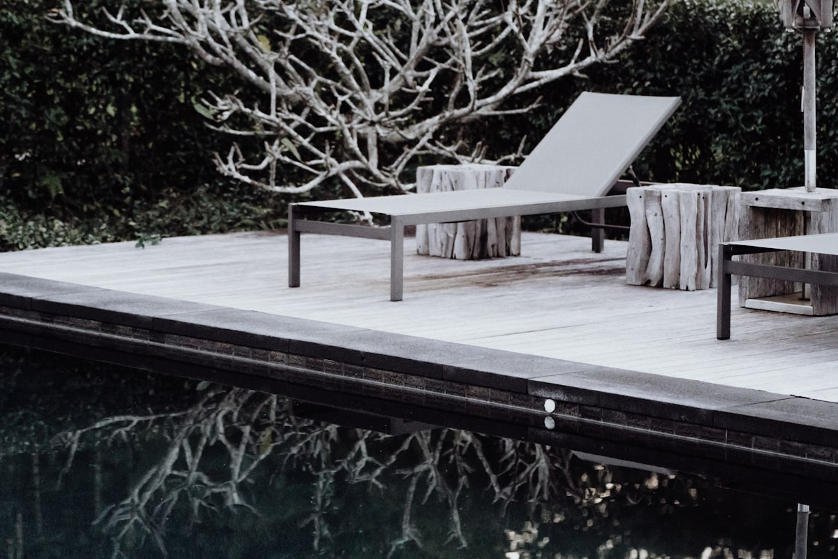 brown wooden bench near body of water during daytime related to Experience Bliss with a Chaise Lounge Bed