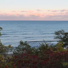 Calm ocean waves under a pastel sky. related to Exploring the Charm: Bed and Breakfasts in Michigan