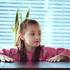 Child sitting on the table looking away to side. Portrait of a little girl in deep thought. related to Girls Window Valance Ideas and Options