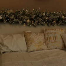 Christmas garland with lights and ornaments above bed related to The Enchanting World of Lights Around Bed