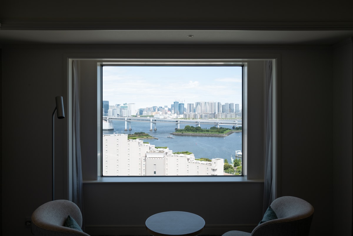 Cityscape view through a large window with chairs. related to Bay Window Valances: Elevating Your Home's Style