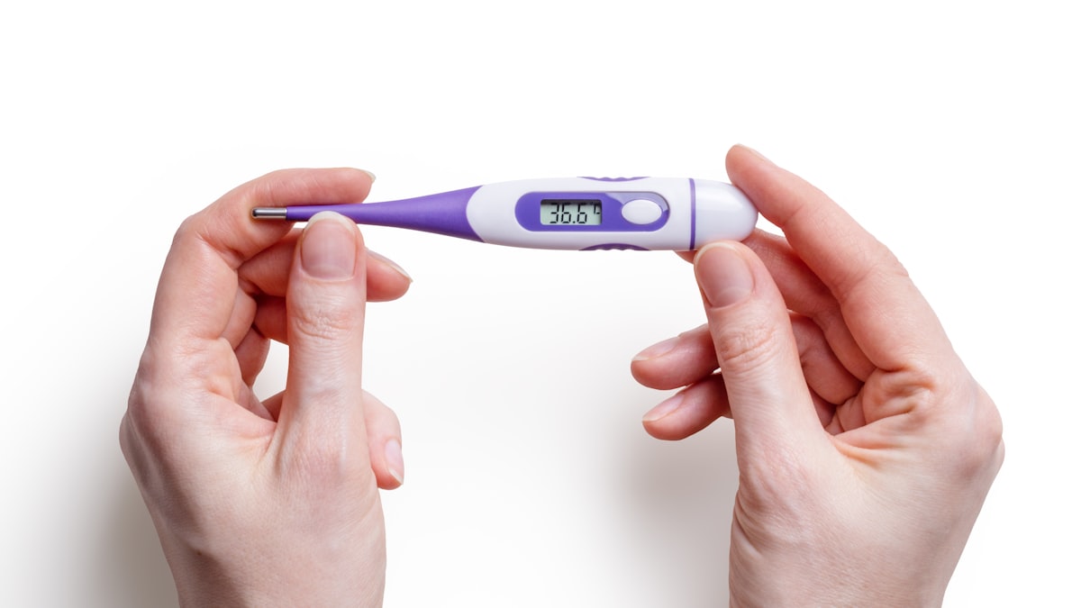 Clean medical thermometer with hands on white background
 related to Warmth on a Smaller Scale: The Benefits of Table Top Chimineas