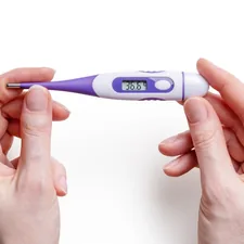 Clean medical thermometer with hands on white background
 related to Warmth on a Smaller Scale: The Benefits of Table Top Chimineas