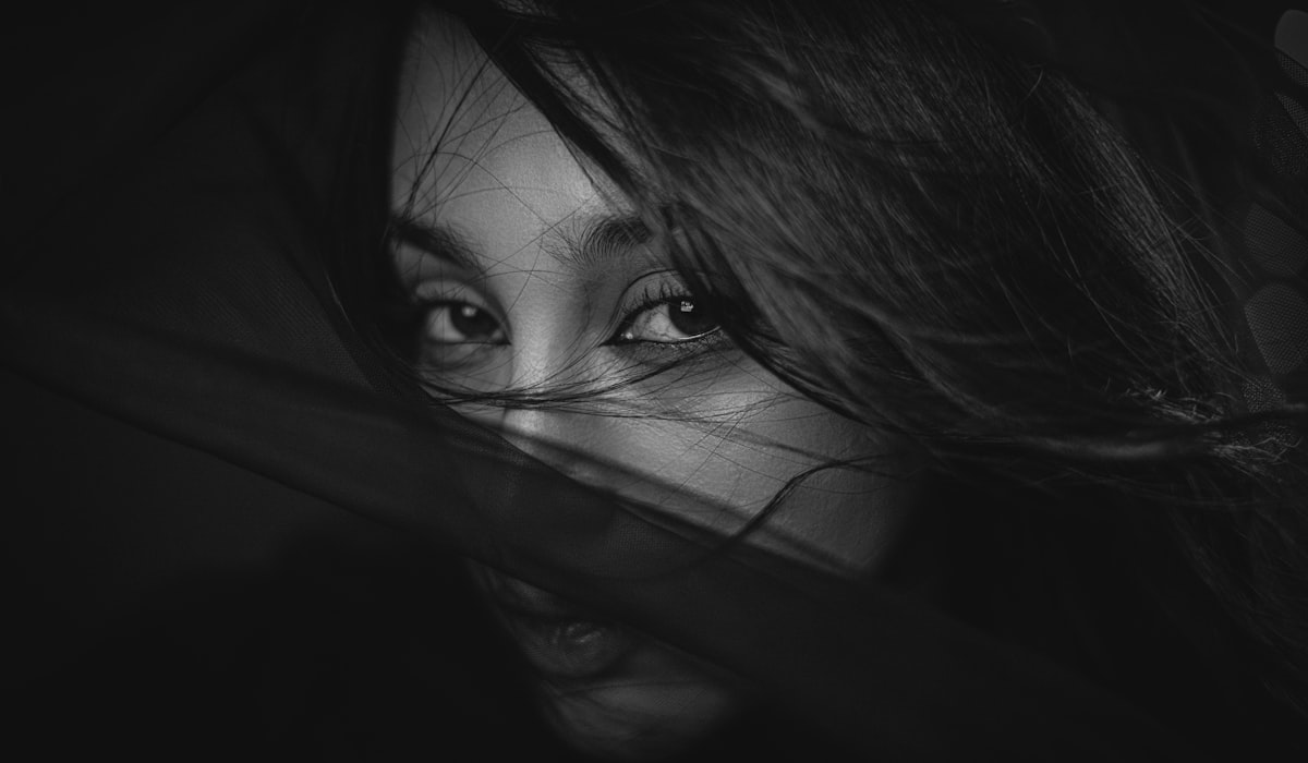 Close-up black and white of a woman's eyes. related to The Mysterious Allure of the Bed of Nails: Uncovering its Secrets