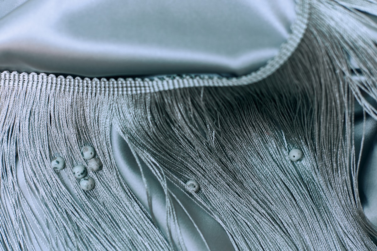 Close-up details of lace, beads, pearls, and threads used in fashion and tailoring. High-quality textile elements and handmade embellishments, showcasing the craftsmanship and elegance of garment design. Perfect for illustrating couture, sewing, fashion production, and artisanal clothing aesthetics. related to Twin Matelasse Coverlet Sale | Discounted Prices