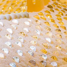 Close-up of a textured surface with gold and silver embellishments. related to Experience the Unbeatable Luxury of Gold Bed Comforters