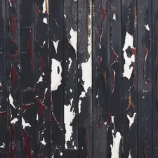 Close Up Of Peeling Black Paint On Wooden Paneling - A close up view of weathered black wooden paneling. The paint is peeling and chipping, revealing layers of red and white paint beneath. The texture is rough and uneven, creating an abstract pattern. related to Elevate Your Home Decor with a Black Distressed Sideboard