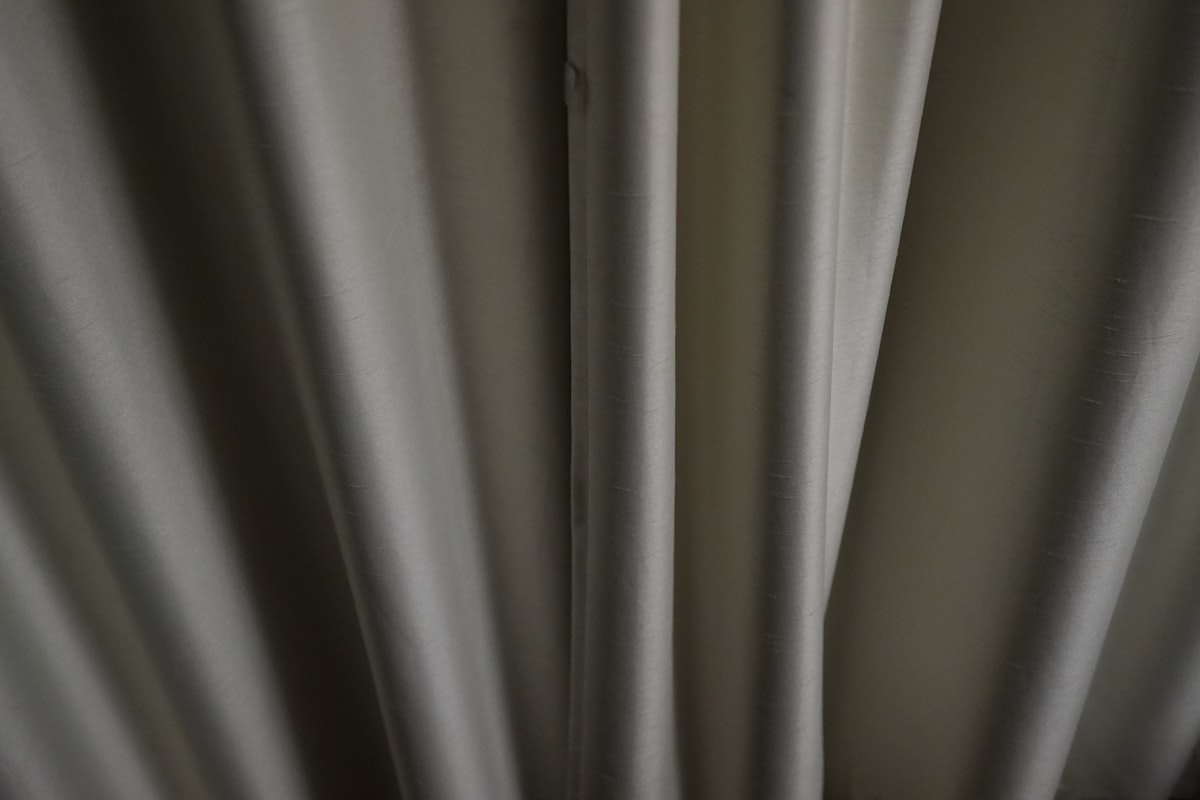 Close-up of textured gray fabric with vertical folds. related to Pinch Pleated Valances