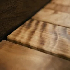 Close-up of wooden planks with a rich, textured grain pattern and warm, natural tones. related to Elegance Meets Durability: Solid Wood Sideboards for Your Home