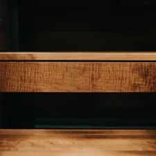 Close-up of wooden sauna bench with a rich, dark brown finish and visible wood grain texture. related to Corner Storage Bench Entryway
