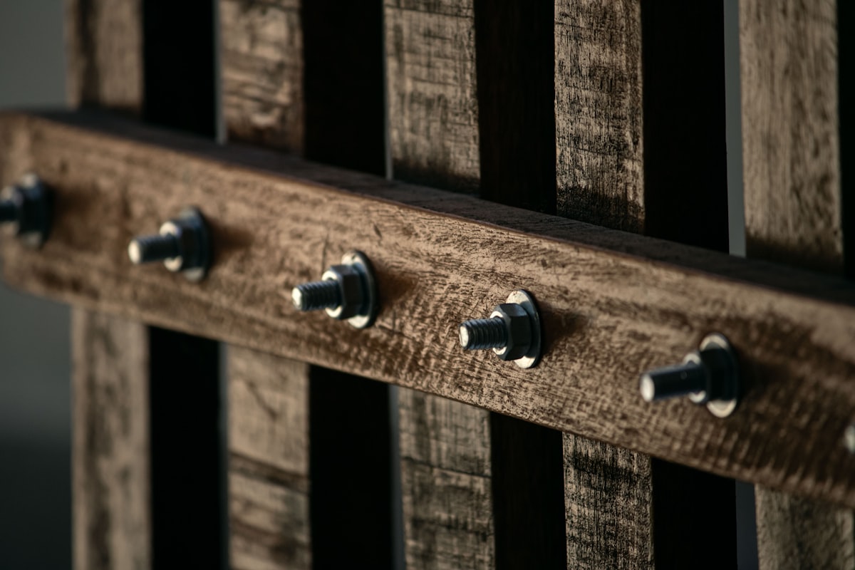 Closeup shot of a wooden handmade gate with rustic wood and metal screws related to The Ultimate Guide to Bed Frames with Hooks