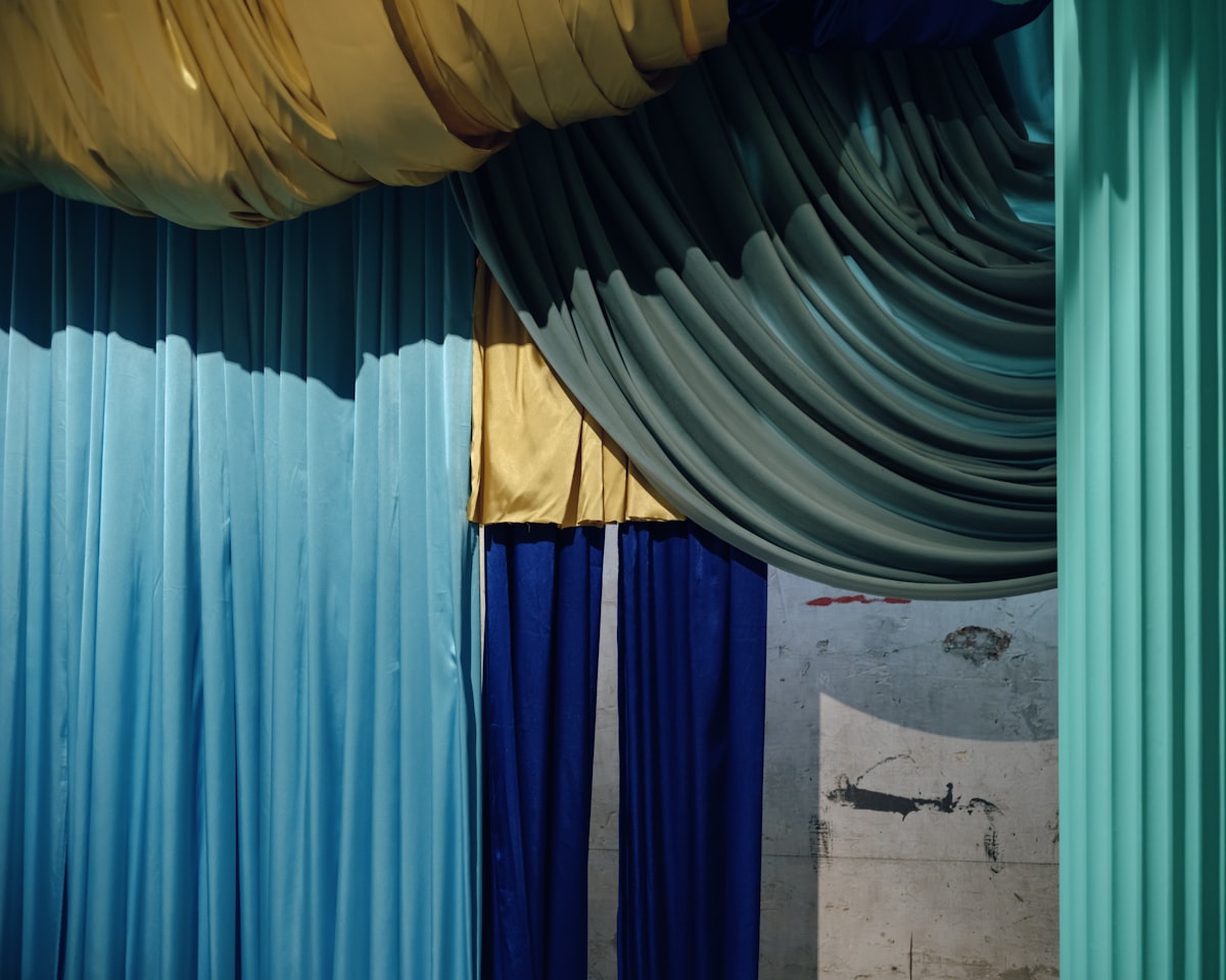 Colorful fabrics drape in a theatrical arrangement. related to Valances and Curtains: Elevating Your Home's Style