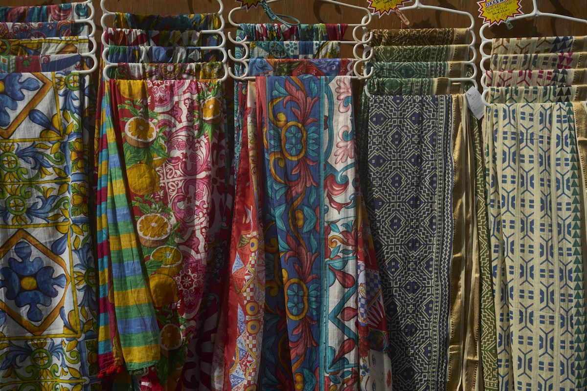 Colorful patterned fabrics hanging on display related to Hanging Scarf Valances: Elevate Your Home Decor