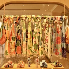 Colorful scarves are displayed in a store. related to Hang Scarf Valance Curtains Like a Pro