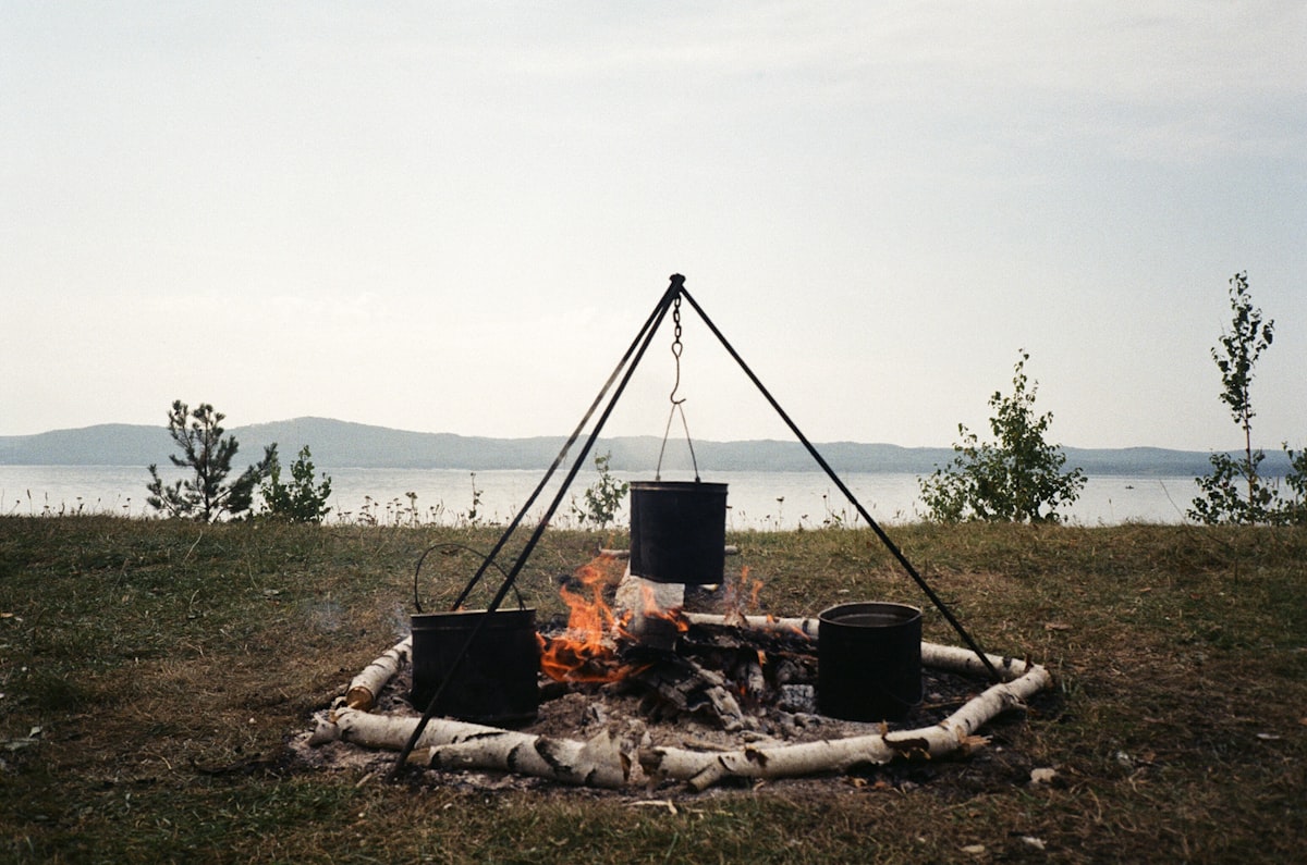 cooking outdoor dinner on a bonfire near the lake and mountains. Film shoot.🌟 Your Creative Projects Await! 🌟 If you’ve used this photo in your work, I’d love to see it! Please send a link to your project via email at dinabdmsh@gmail.com Your creativity inspires me, and I’m excited to see how you’ve brought this image to life. If you appreciate my work and would like to support me, feel free to check out my donation link https://paypal.me/dinamazing Thank you! related to The Magic of Outdoor Cooking: Mastering Chiminea Cuisine