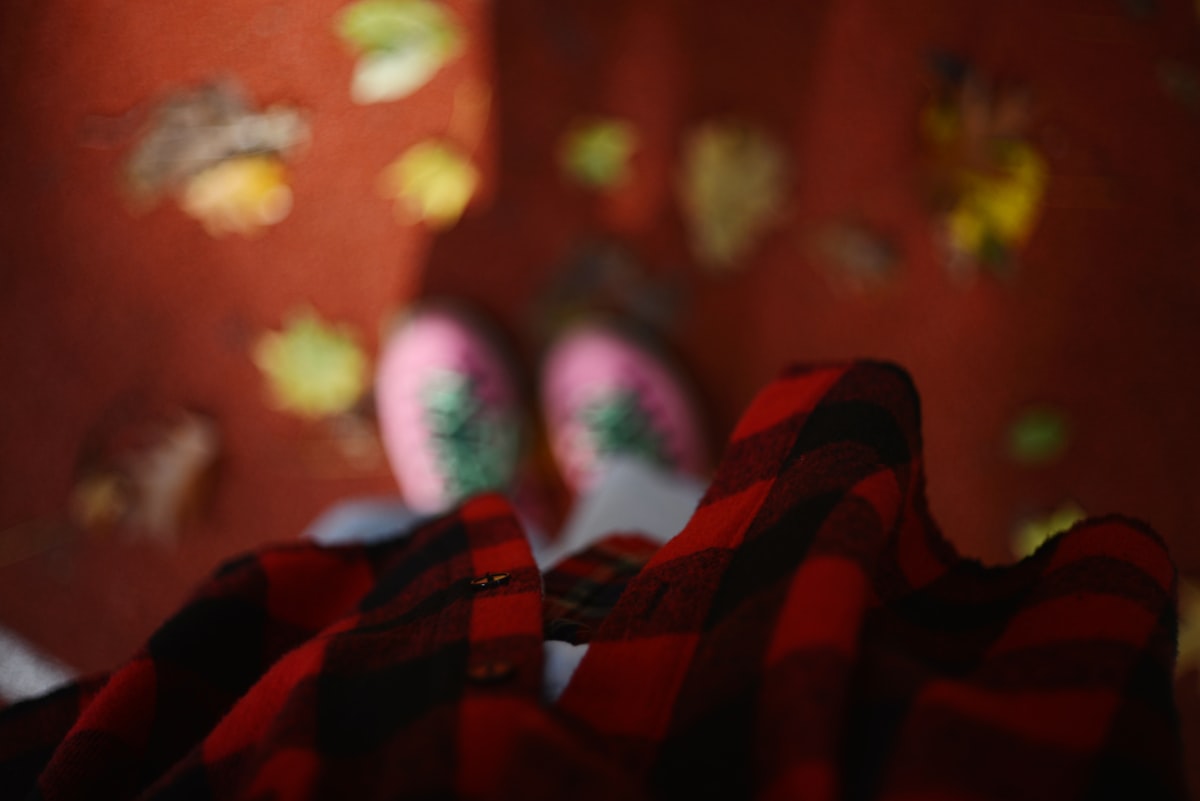 Cozy flannel shirt and socks with autumn leaves related to The Bold Beauty of Red and Black Plaid Bedding: A Trendy Touch for Your Bedroom