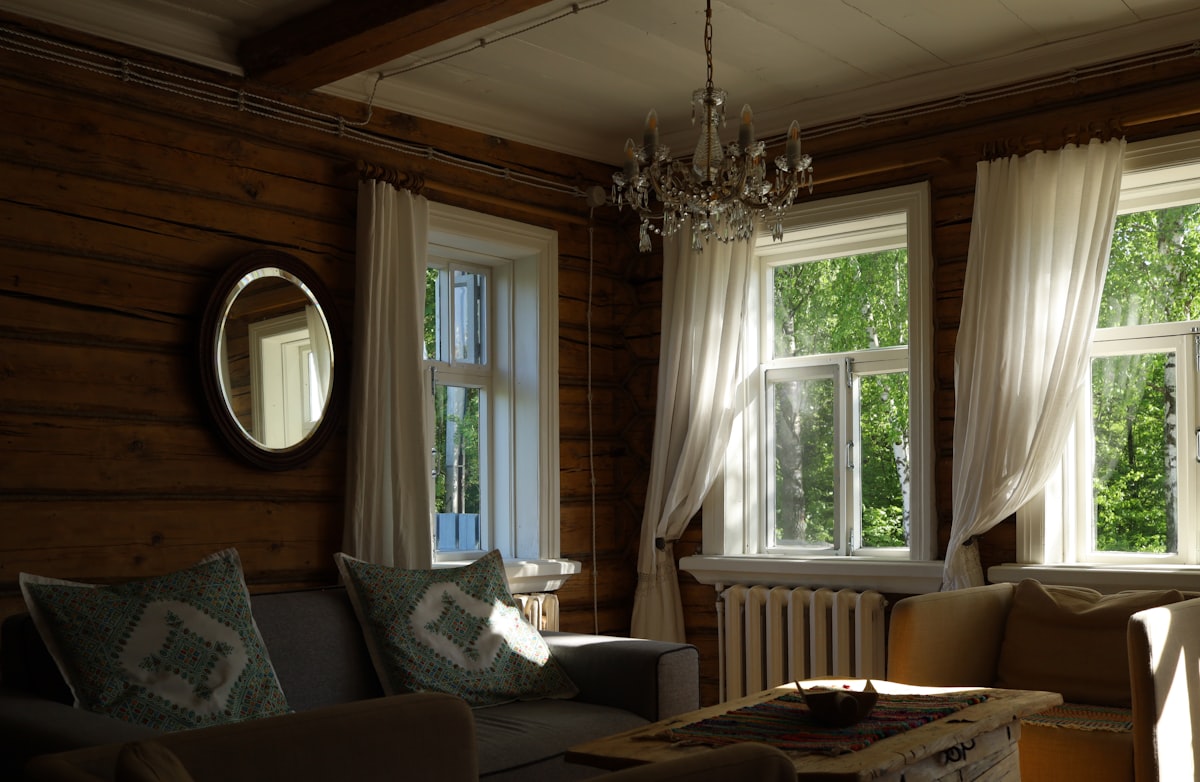 Cozy living room with rustic wooden walls and bright windows. related to Country Valances & Swags