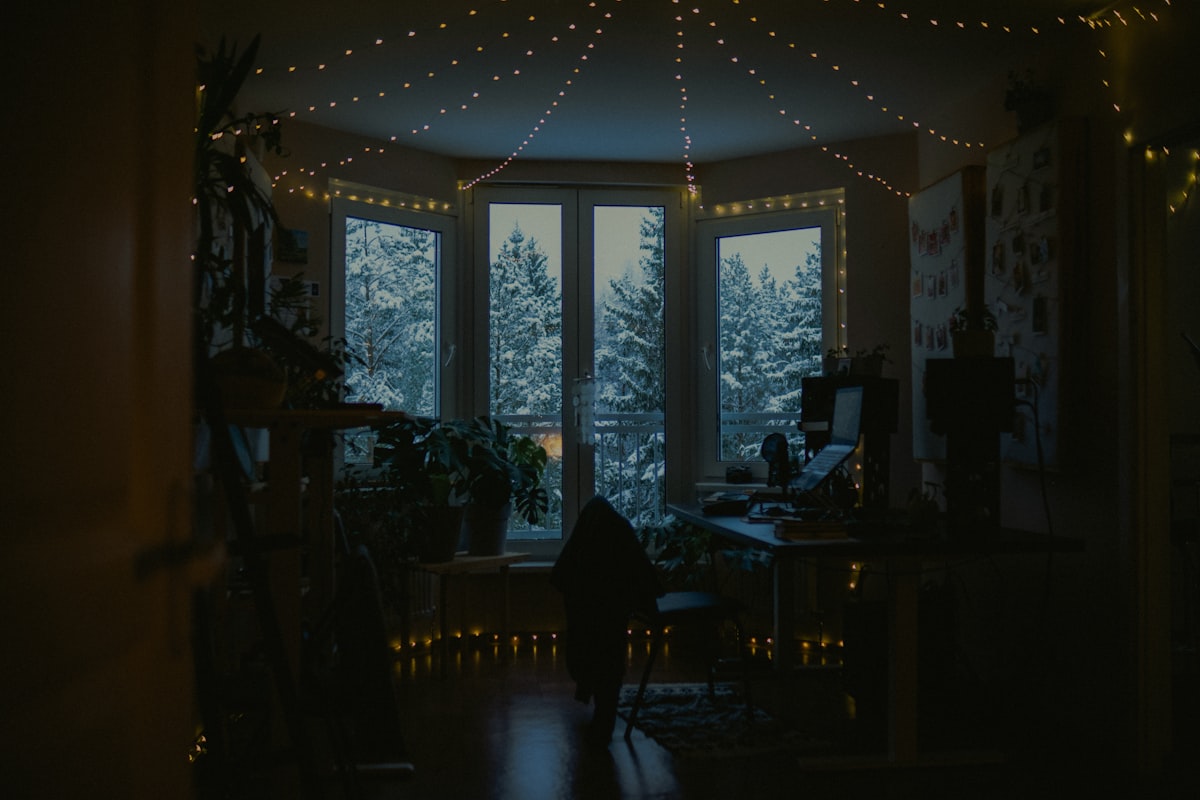 Cozy room with fairy lights and snowy window view. related to Window Wonderland: Discover the Magic of Free Valance Patterns