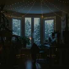 Cozy room with fairy lights and snowy window view. related to Window Wonderland: Discover the Magic of Free Valance Patterns