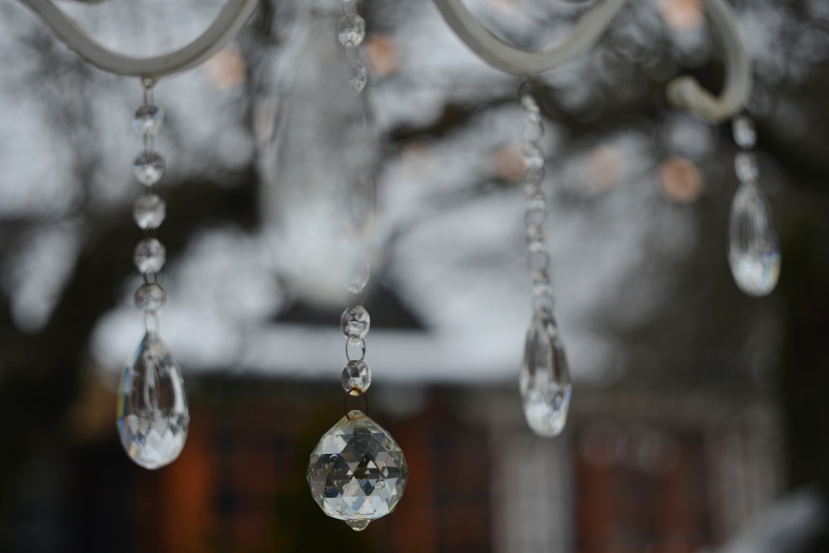 Crystal ornaments hanging from a white structure related to Elegant Window Dressing: A Guide on How to Hang a Window Scarf Valance
