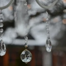 Crystal ornaments hanging from a white structure related to Elegant Window Dressing: A Guide on How to Hang a Window Scarf Valance