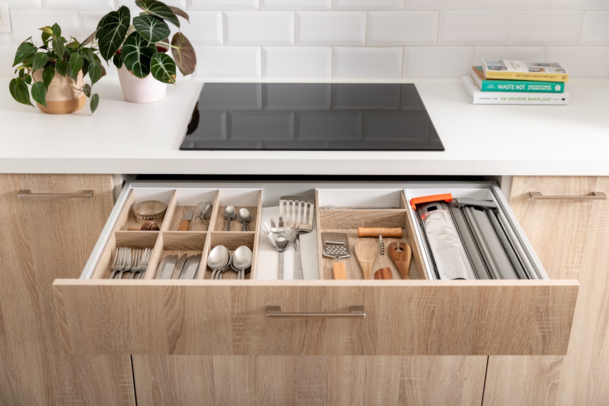 Cutlery drawer in a wooden and white kitchen with wooden drawer inserts. related to Maximizing Storage Space with Drawers Under Bed