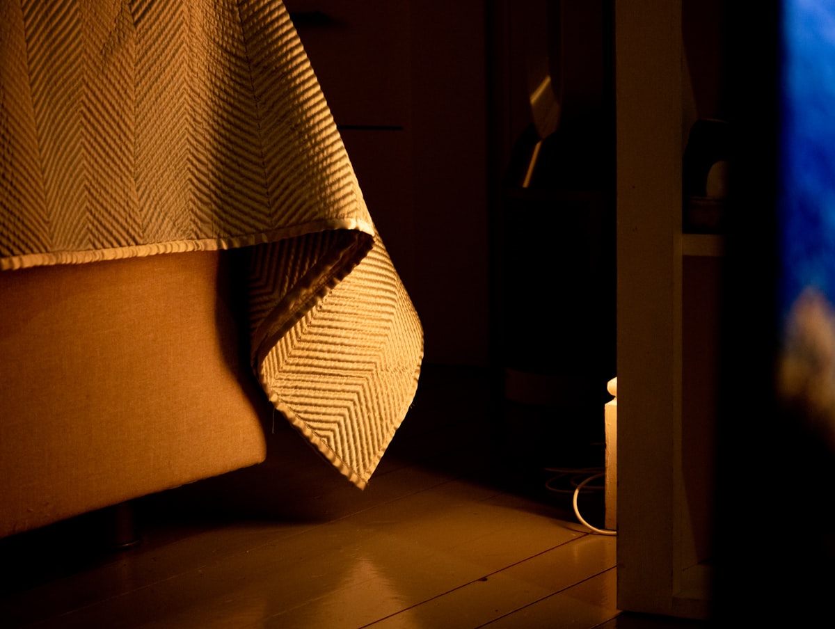 Dark bedroom illuminated by orange light. related to King Bed Coverlet: Elevate Your Bedroom Style