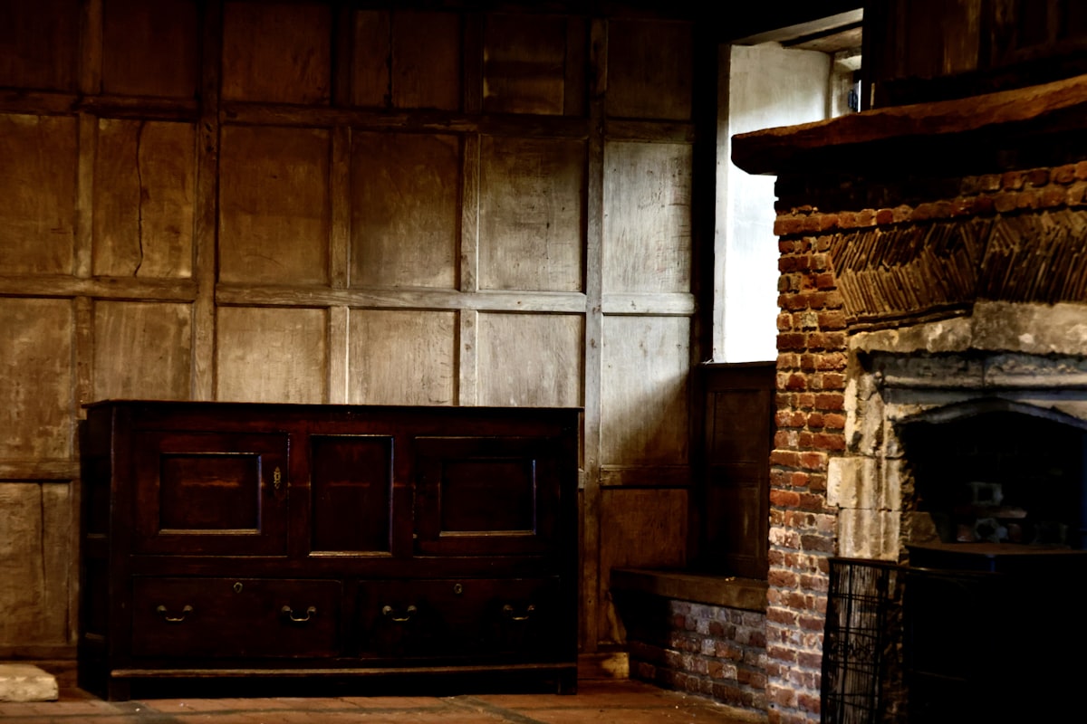Dark, old interior with wood paneled walls and fireplace. related to The Timeless Beauty of English Oak Sideboards
