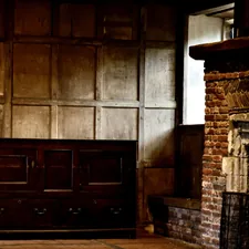 Dark, old interior with wood paneled walls and fireplace. related to The Timeless Beauty of English Oak Sideboards