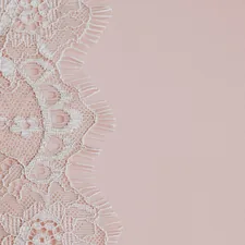 Delicate white lace fabric on a soft pink background. related to Elegant Bathroom Essentials: Lace Shower Curtains with Valance