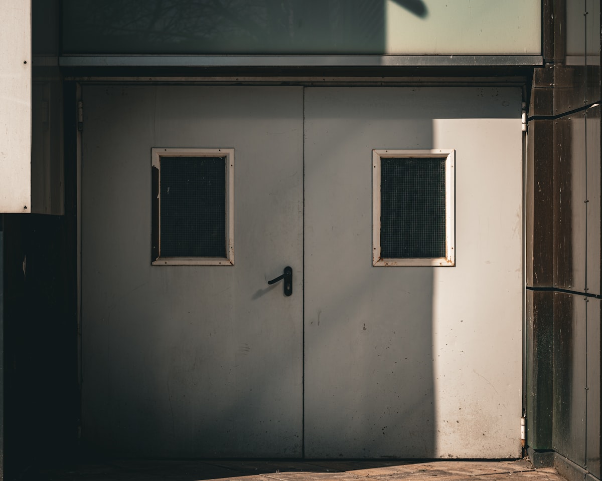 Double gray doors with two small windows related to Double Door Entryway: A Guide to Design and Functionality