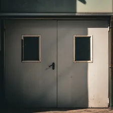 Double gray doors with two small windows related to Double Door Entryway: A Guide to Design and Functionality