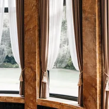 Elegant curtains framing a view of greenery related to The Art of Window Dressing: Valances and Swags