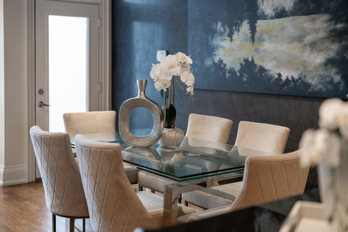Elegant dining room with glass table and upholstered chairs. related to dining room sideboard decorating ideas