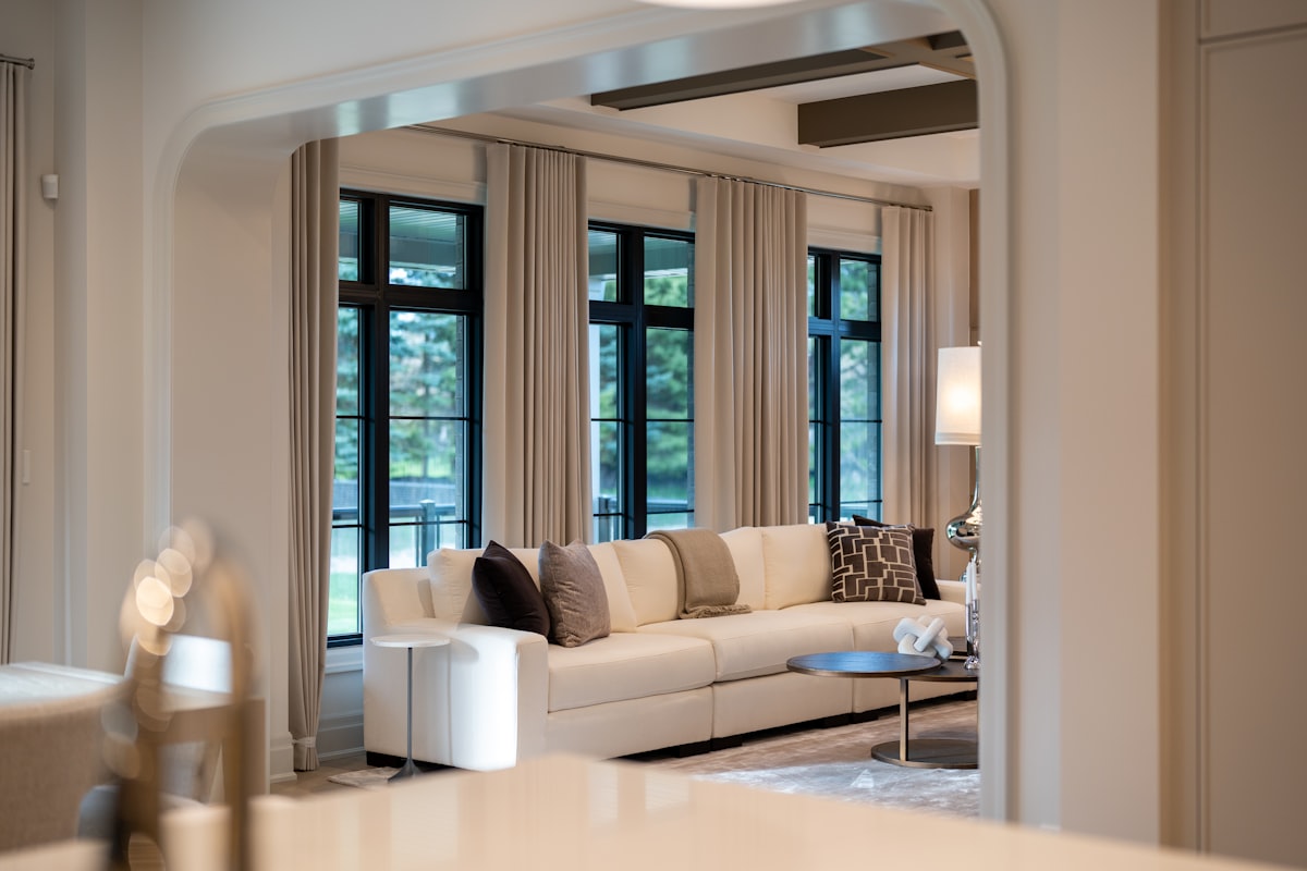 Elegant living room with large sofa and windows related to Valances and Drapes: Elevating Your Home's Style