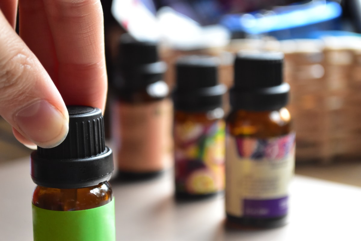 Fingers grabbing essential oils related to Using Essential Oils to Combat Bed Bugs Naturally