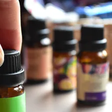 Fingers grabbing essential oils related to Using Essential Oils to Combat Bed Bugs Naturally