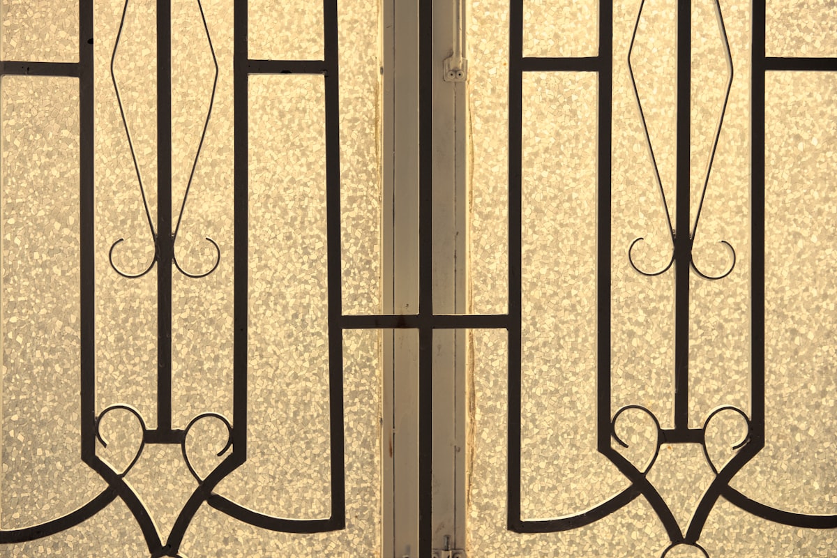 Frosted glass door with intricate black metal scrollwork design. related to Timeless Elegance: The Beauty of Art Deco Sideboards