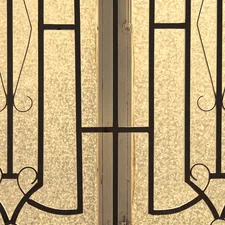 Frosted glass door with intricate black metal scrollwork design. related to Timeless Elegance: The Beauty of Art Deco Sideboards