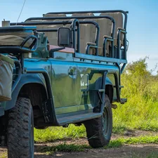 Game drive vehicle in front of grass related to Vision Quest Safari Bed & Breakfast