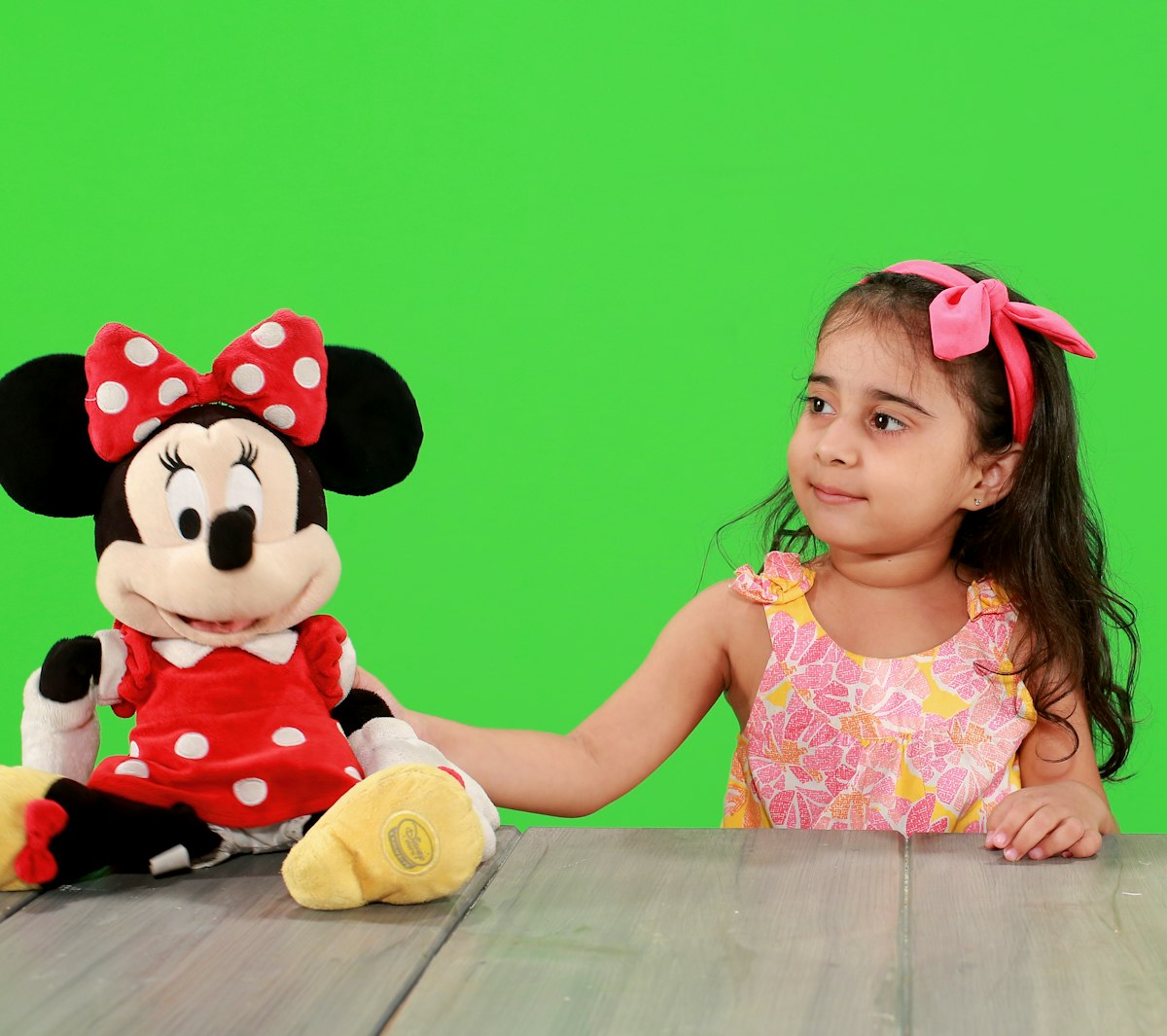 girl in minnie mouse dress sitting beside minnie mouse plush toy related to Minnie Mouse Bed Set for Toddlers: A Magical Sleeping Experience
