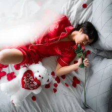 girl in red t-shirt lying on bed related to Elevate Your Love Life: The Allure of Romantic Bedding Sets