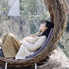 girl in white dress on brown woven basket related to The Cozy Bird Nest Bed