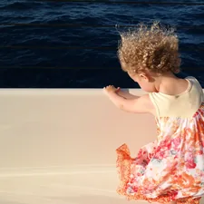 girl in white tank top and pink floral skirt standing on water during daytime related to Nautical Baby Girl Bedding: A Perfect Blend of Comfort and Style