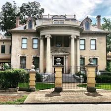 gray concrete pillared building surrounded by trees during daytime related to Discover the Luxury of DuPont Mansion Bed & Breakfast