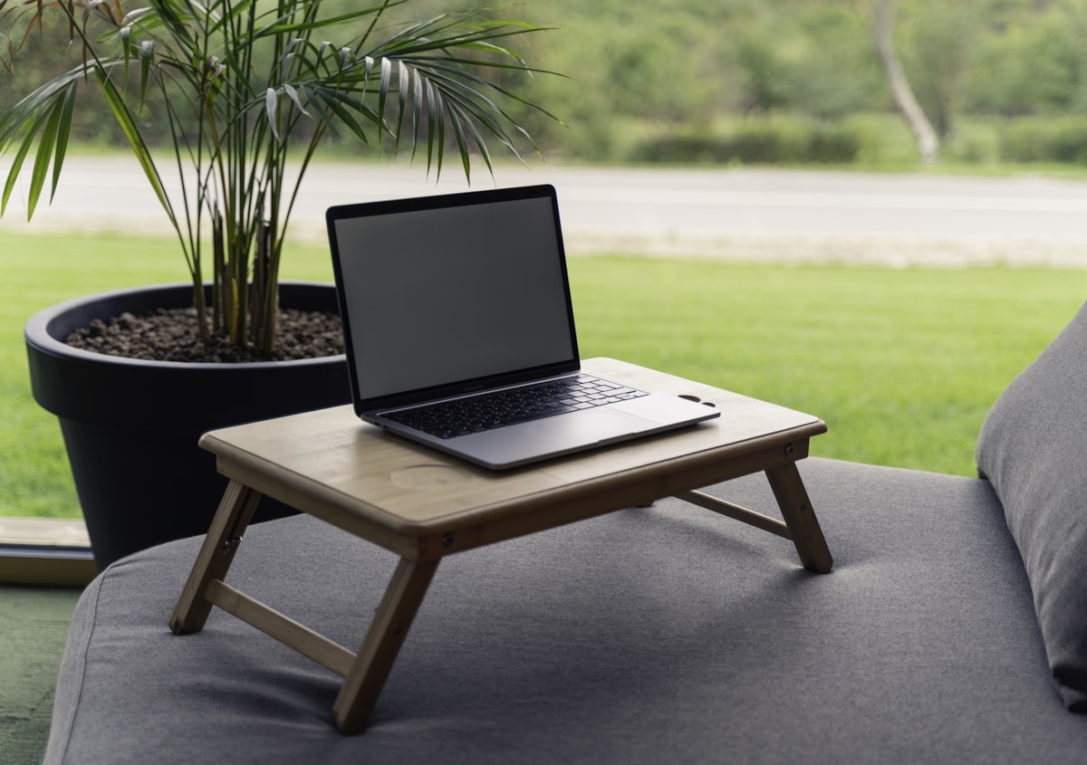 Great view with laptop on a table with plant related to Transform Your Laptop Experience with the Perfect Bed Tray