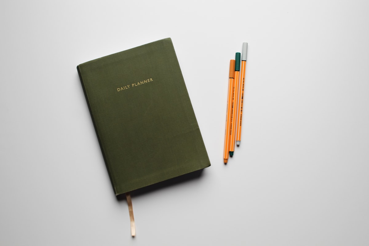 green book with pencils on white table related to Sage Green Coverlet: A Comprehensive Guide